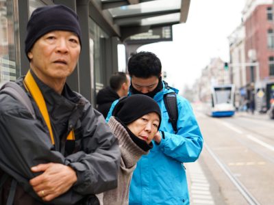 Asian family waiting for bus at bus stop in Europe trip